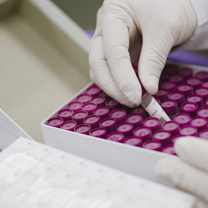 Scientist removing vial from box